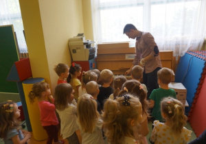 Pan Karol pokazuje dzieciom pianino